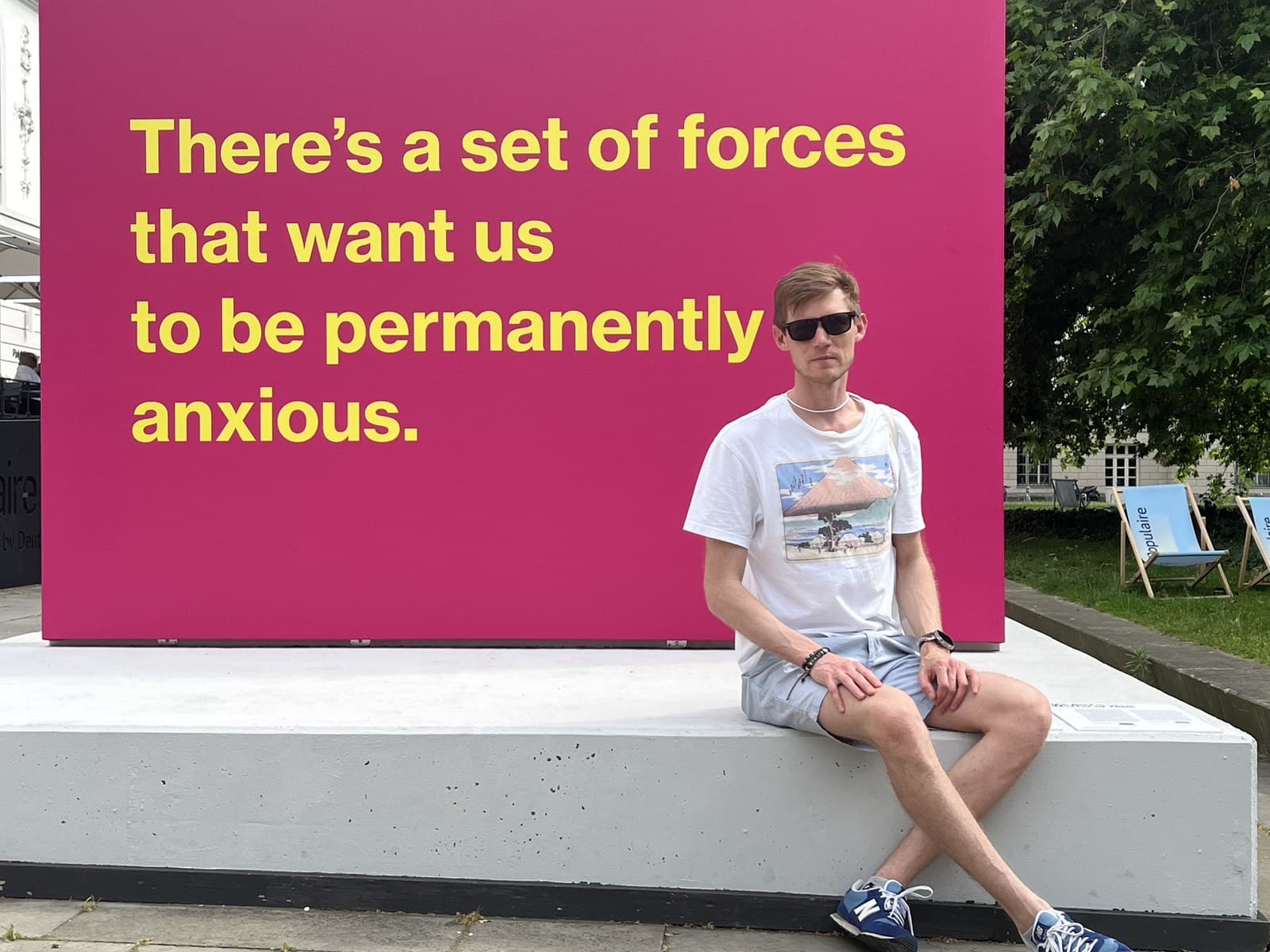 Alex Lindholm seated beside a wall quote about permanent anxiety